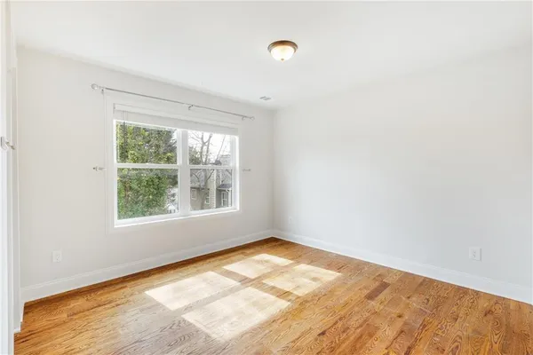 a view of a room with wooden floor and a window