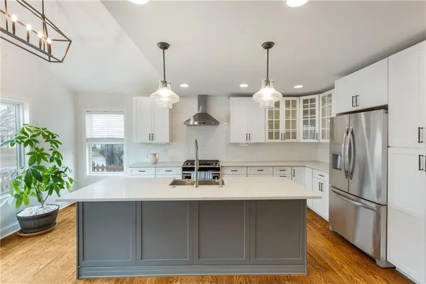 a kitchen with a refrigerator a sink and potted plant