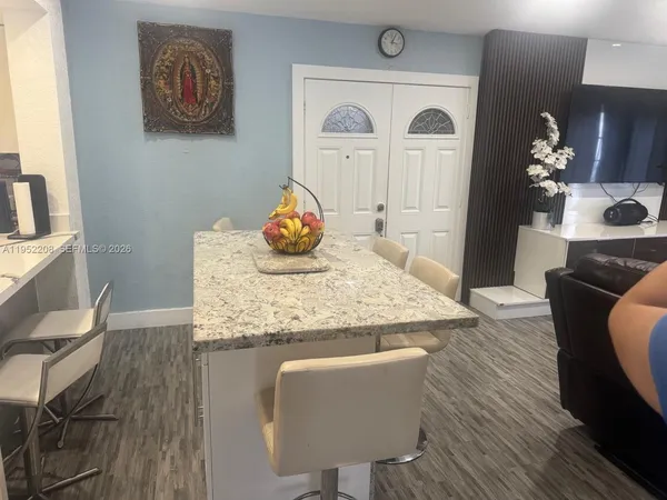 a kitchen with a table chairs and wooden floor