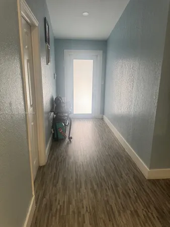 an empty room with wooden floor and a window