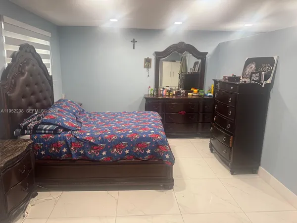 a bedroom with a bed and a mirror on dresser