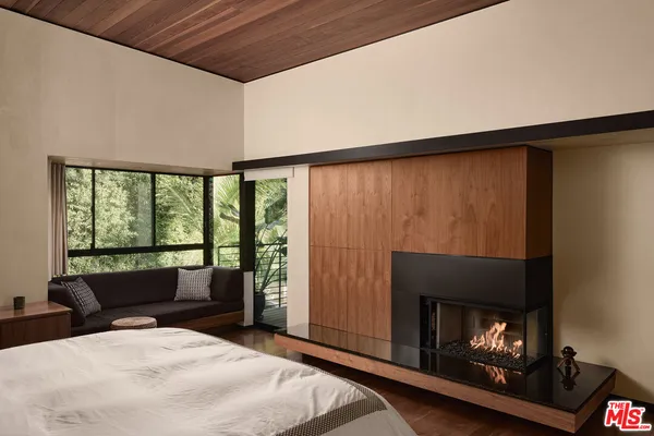 a bedroom with a bed and a flat tv screen on the dresser