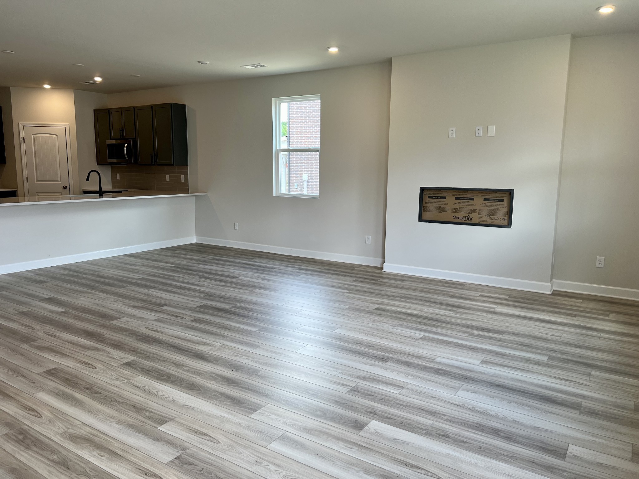 4111 Dwight Way Murfreesboro, TN 37128 - Photo 16 of 28 an empty room with wooden floor and a kitchen view