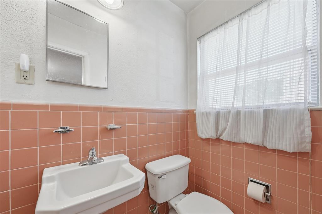 206 West Ridgewood Drive Garland, TX 75041 - Photo 15 of 21 a bathroom with a toilet a sink and mirror