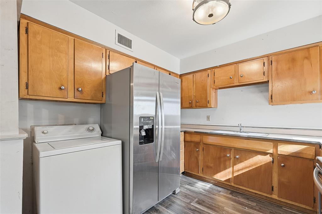 206 West Ridgewood Drive Garland, TX 75041 - Photo 4 of 21 a kitchen with a refrigerator sink and cabinets
