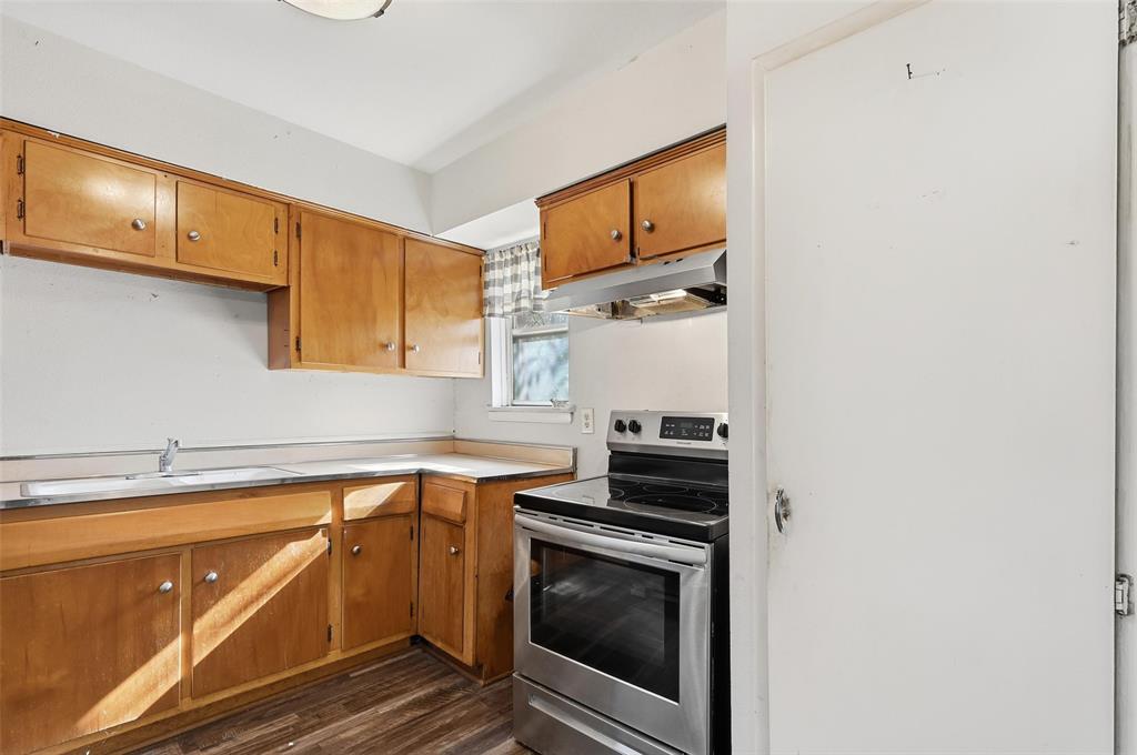 206 West Ridgewood Drive Garland, TX 75041 - Photo 5 of 21 a kitchen with a sink stove and cabinets
