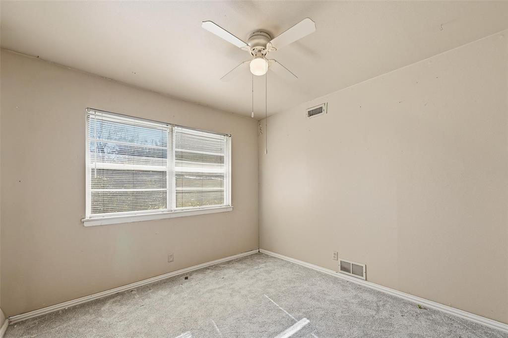 206 West Ridgewood Drive Garland, TX 75041 - Photo 9 of 21 an empty room with a window and a fan