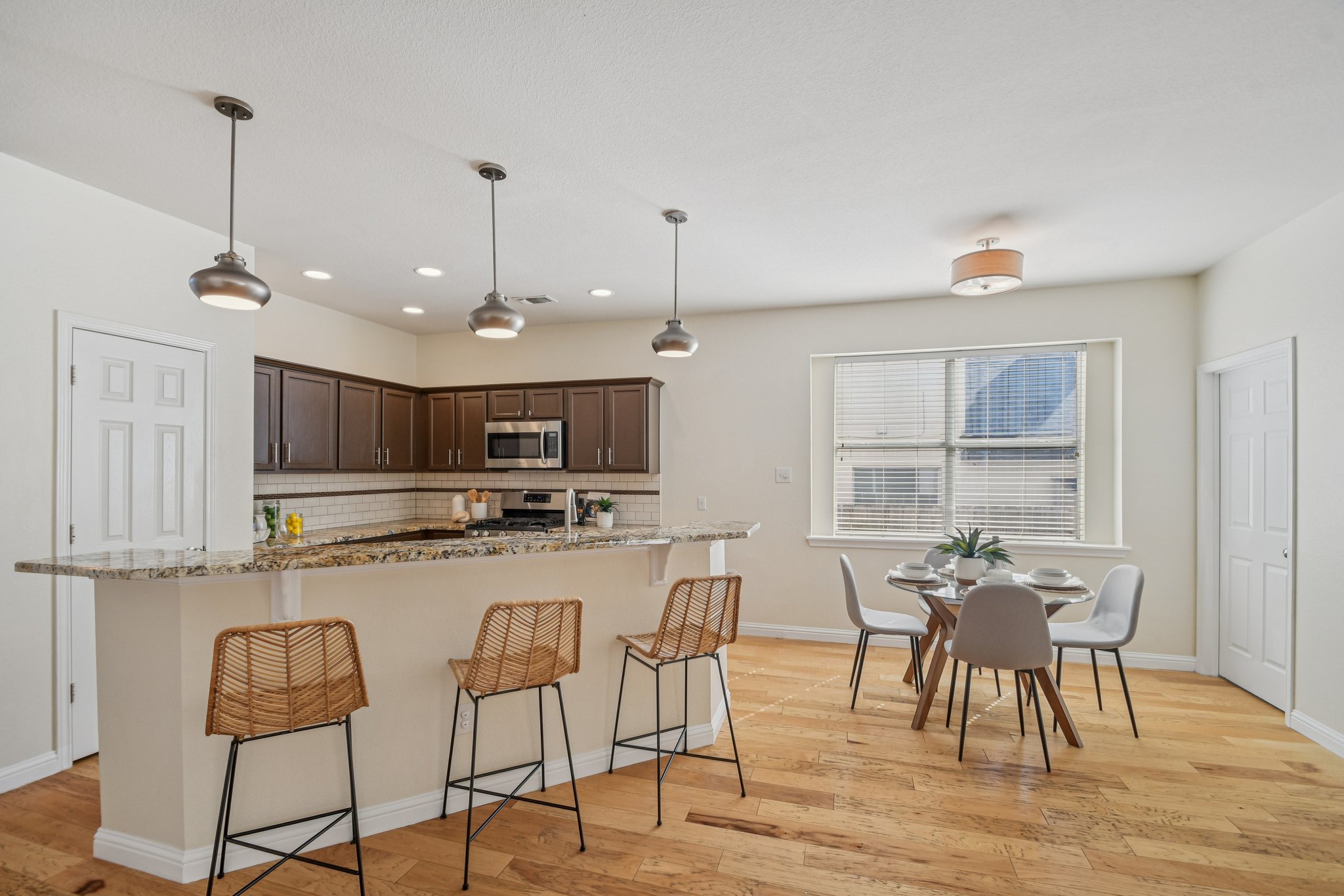 5947 Lomita Verde Circle Austin, TX 78749 - Photo 14 of 40 a kitchen with stainless steel appliances kitchen island granite countertop a dining table chairs and a refrigerator
