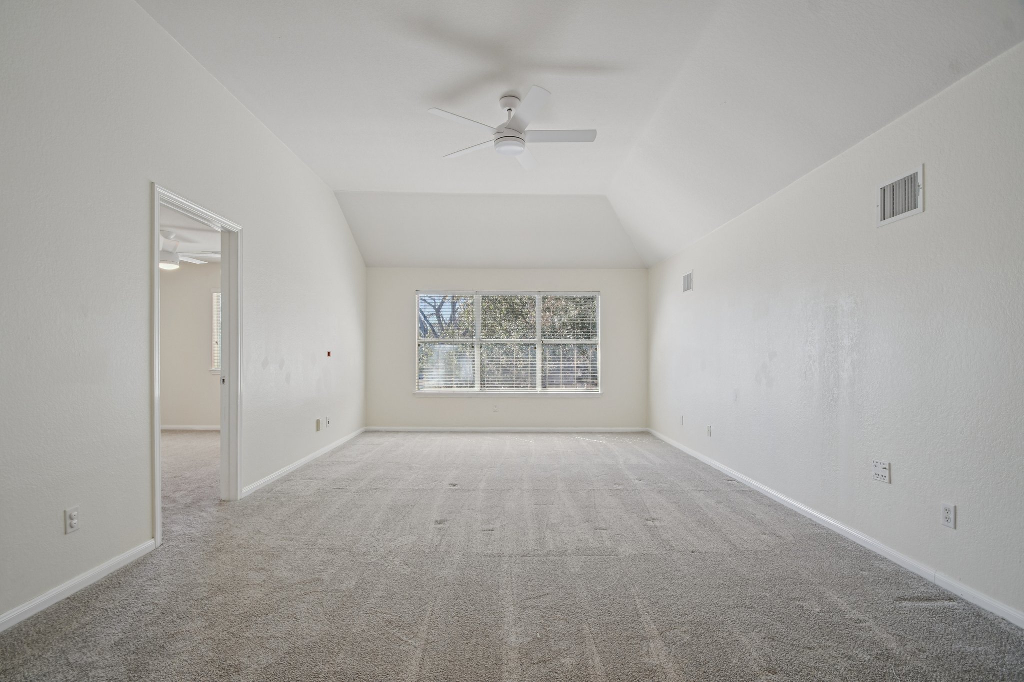 5947 Lomita Verde Circle Austin, TX 78749 - Photo 25 of 40 Extra large den or playroom featuring a ceiling fan, vaulted ceiling, and light carpet