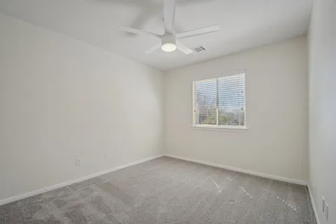 an empty room with a bathroom and window