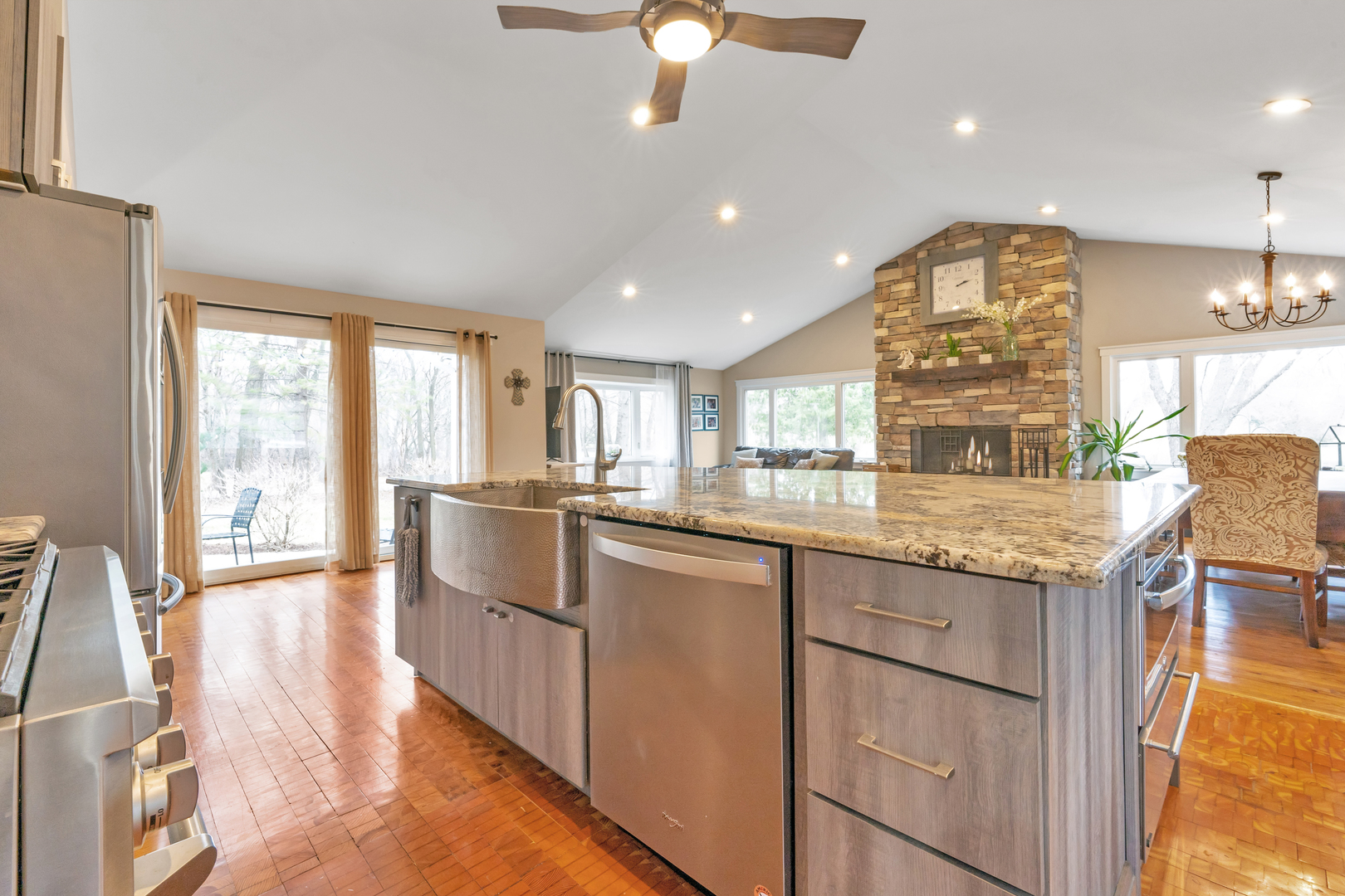 349 Haman Road Inverness, IL 60067 - Photo 5 of 36 a open kitchen with granite countertop a stove top oven a sink a dining table and chairs with wooden floor