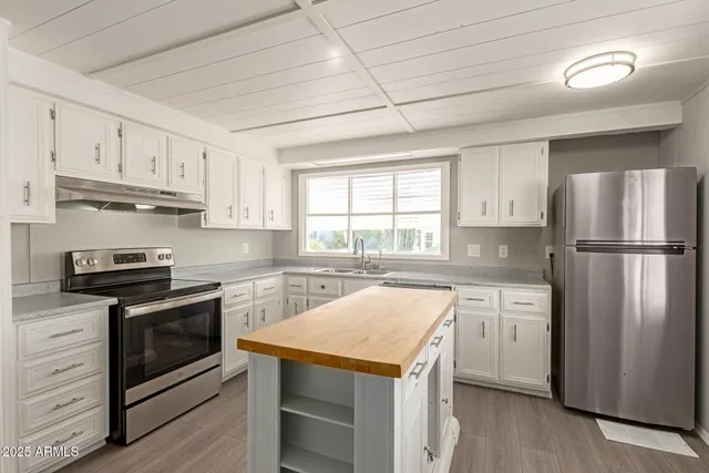 a kitchen with stainless steel appliances granite countertop a stove a refrigerator and a sink