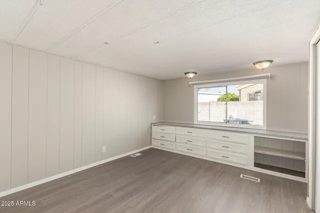 a room with painting on the wall and a window