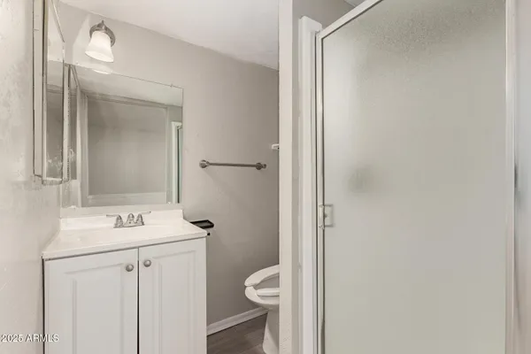 a bathroom with a toilet sink vanity and mirror