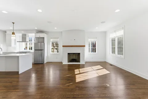 a view of a living room a kitchen and a fireplace