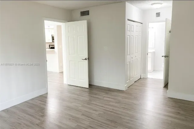 a view of a hallway with wooden floor