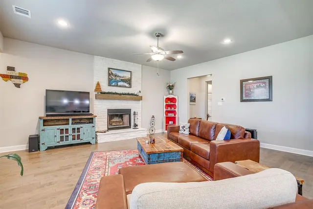 a living room with furniture a flat screen tv and a fireplace
