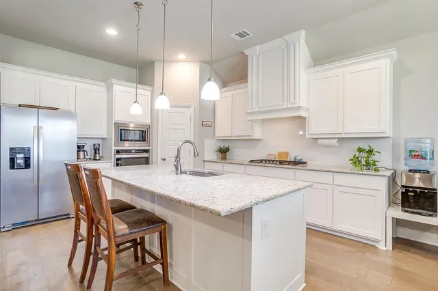 a kitchen with kitchen island a table and chairs in it