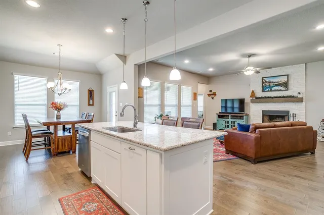 a large kitchen with kitchen island a sink a stove a dining table and chairs