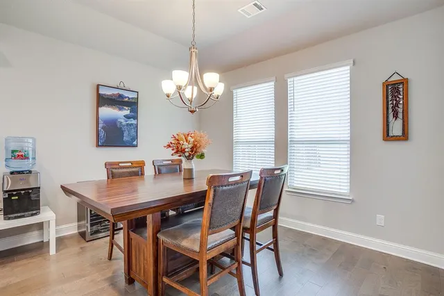 a dining room with furniture a chandelier and wooden floor