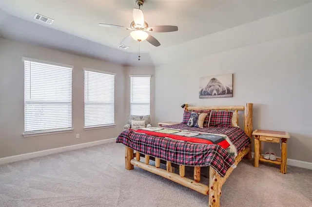 a bedroom with a bed a chandelier and a chair