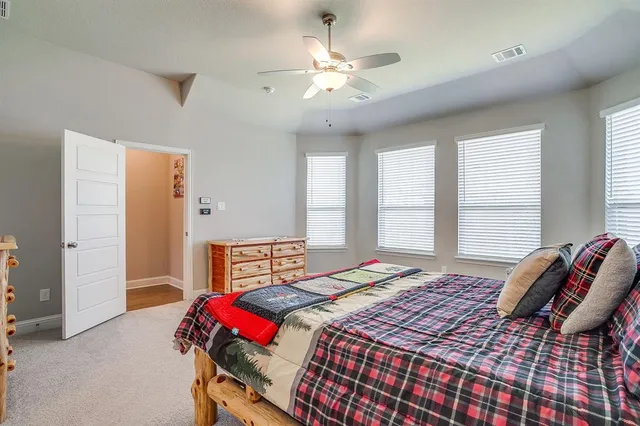 a bedroom with a large bed and a chandelier