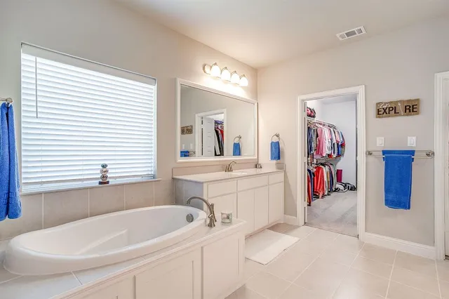 a white bath tub sitting next to a bathroom sink