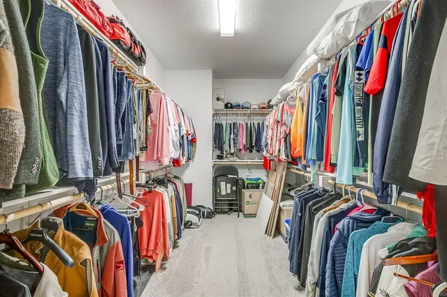 a view of walk in closet with clothes