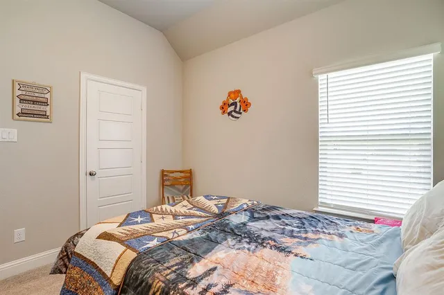 a bedroom with a bed and a window