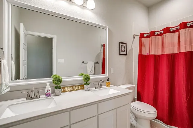 a bathroom with a sink vanity mirror and toilet
