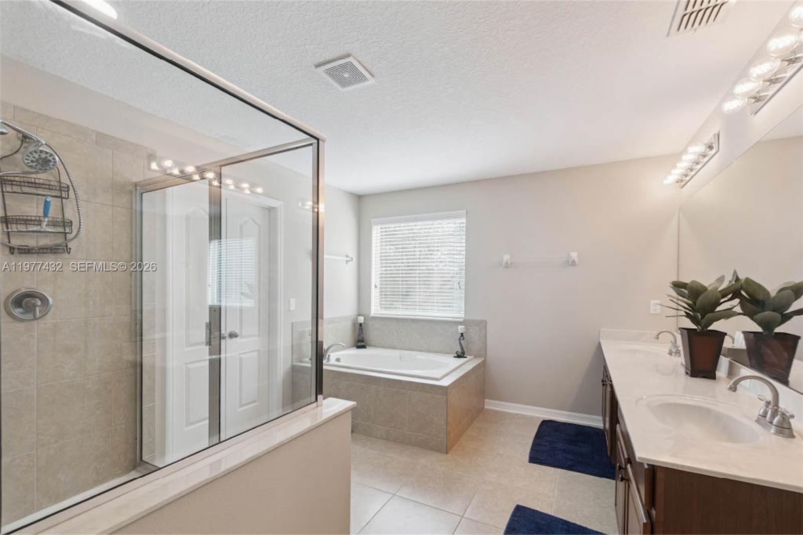 2502 Woodside Ridge Drive Apopka, FL 32712 - Photo 16 of 37 a bathroom with a tub shower sink and mirror