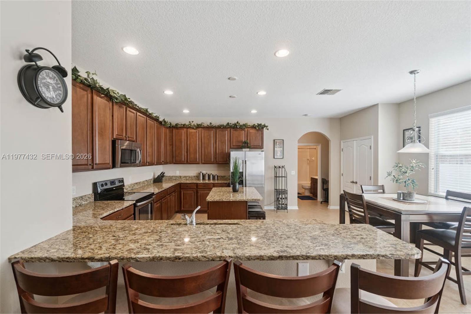 2502 Woodside Ridge Drive Apopka, FL 32712 - Photo 5 of 37 a kitchen with granite countertop a table chairs stove and cabinets