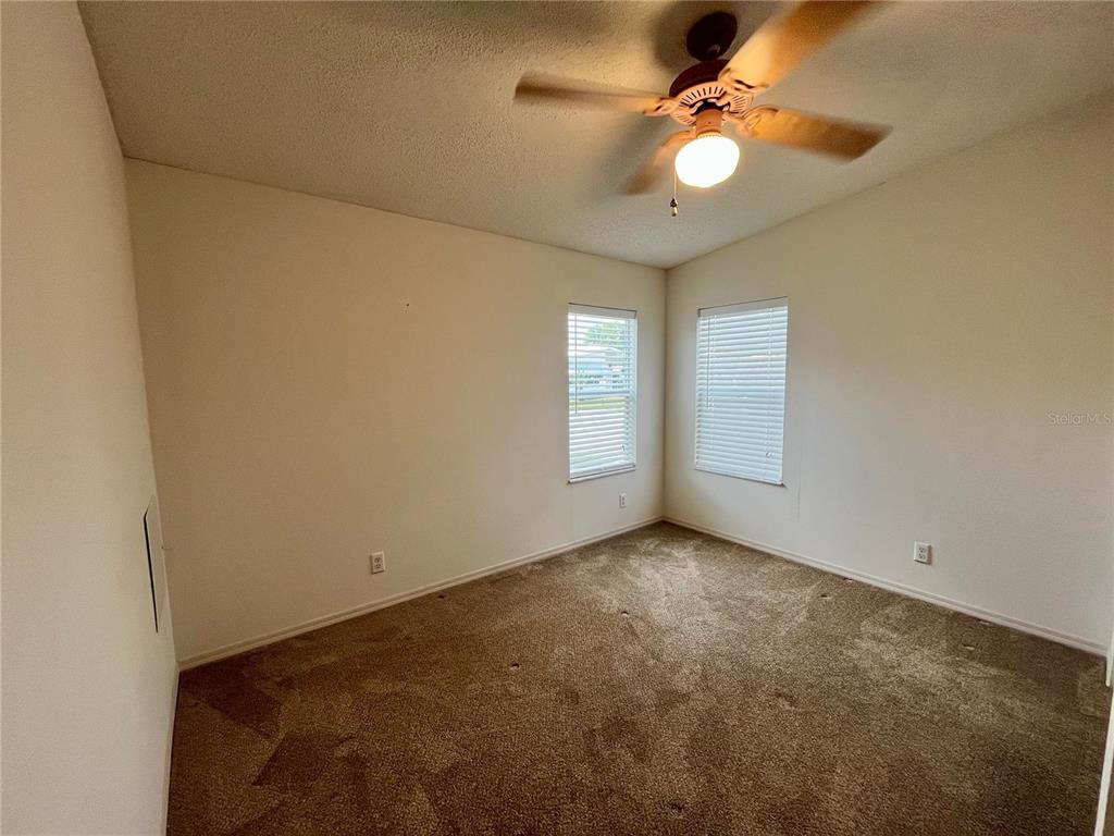 10614 Hayden Avenue New Port Richey, FL 34655 - Photo 17 of 23 an empty room with windows and fan