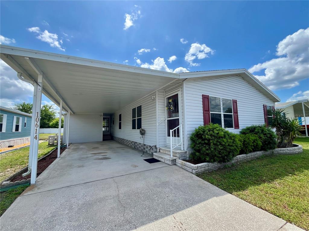 10614 Hayden Avenue New Port Richey, FL 34655 - Photo 2 of 23 a view of a house with a yard and potted plants