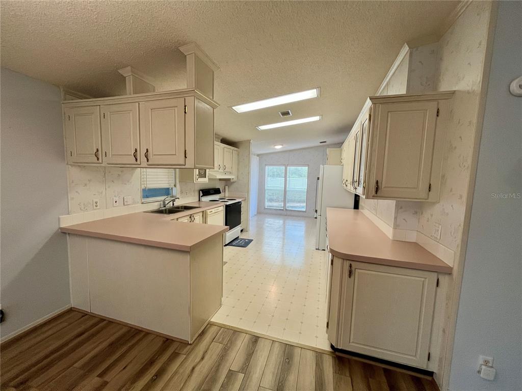 10614 Hayden Avenue New Port Richey, FL 34655 - Photo 4 of 23 a kitchen with a sink stove and cabinets