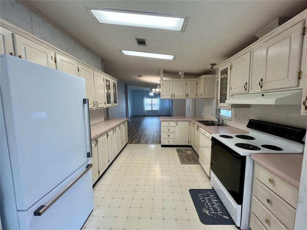 10614 Hayden Avenue New Port Richey, FL 34655 - Photo 5 of 23 a kitchen with stainless steel appliances a refrigerator a sink a stove a microwave and cabinets