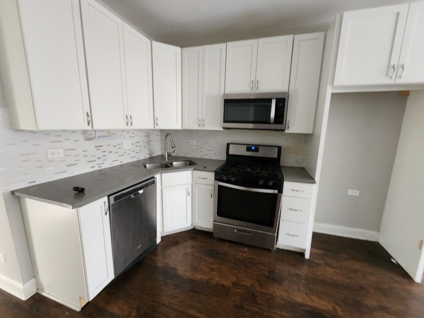 12211 South Wallace Street Chicago, IL 60628 - Photo 13 of 17 a kitchen with granite countertop white cabinets and stainless steel appliances