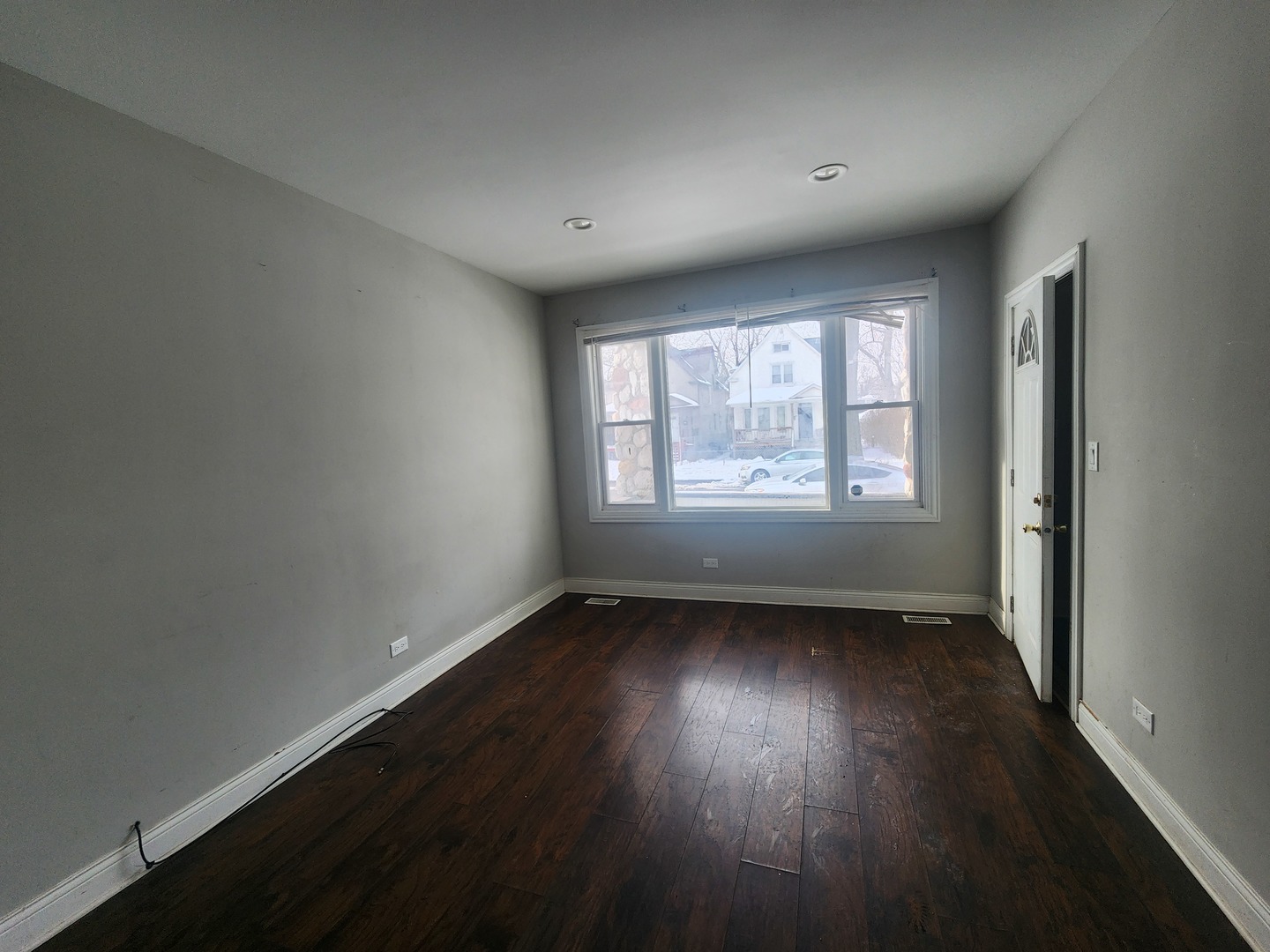 12211 South Wallace Street Chicago, IL 60628 - Photo 4 of 17 an empty room with wooden floor and windows