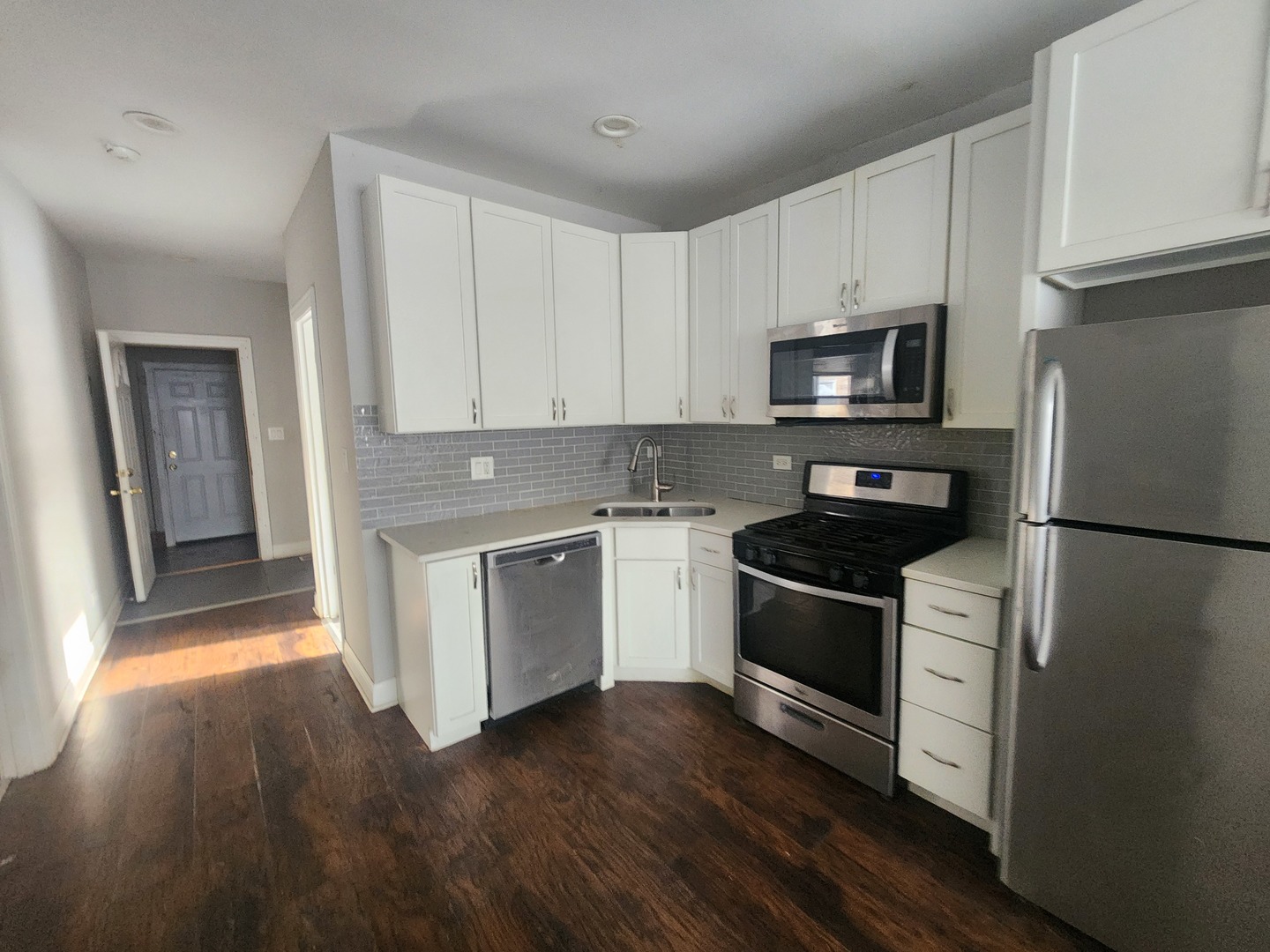 12211 South Wallace Street Chicago, IL 60628 - Photo 5 of 17 a kitchen with granite countertop white cabinets and stainless steel appliances