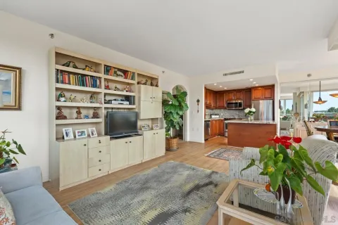 a living room with furniture a flat screen tv and a kitchen