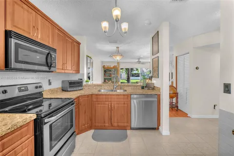 a kitchen with stainless steel appliances granite countertop a stove a sink dishwasher and a refrigerator