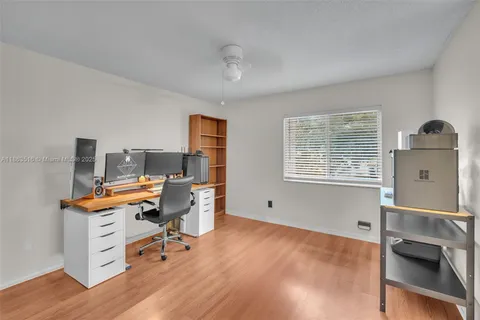 a view of a workspace with furniture and a window