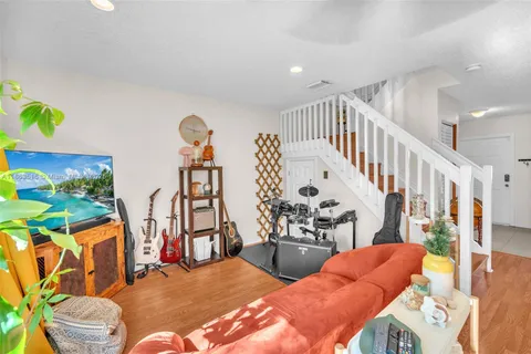 a living room with furniture and wooden floor