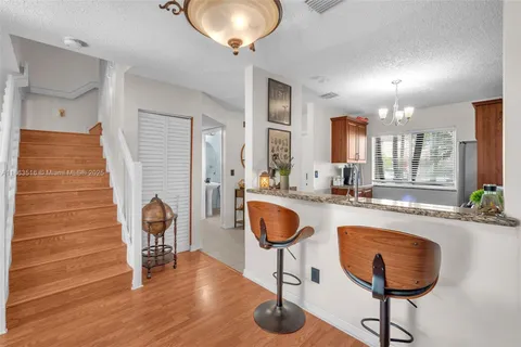 a kitchen with granite countertop a dining table chairs and a chandelier