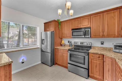 a kitchen with stainless steel appliances granite countertop a refrigerator stove top oven a sink and dishwasher