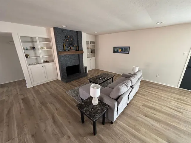 a living room with furniture and a wooden floor