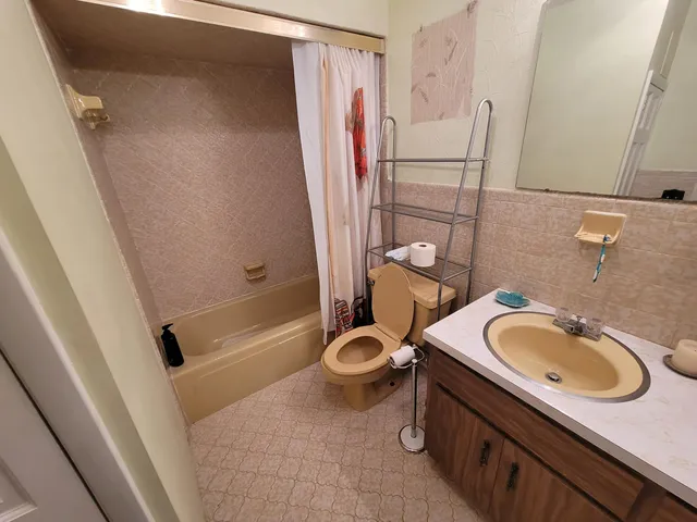 a bathroom with a granite countertop sink toilet and shower