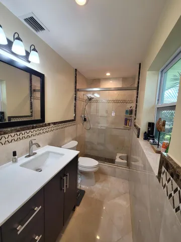 a bathroom with a sink a toilet and a mirror