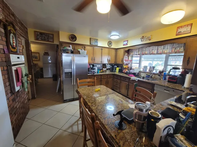 a kitchen with stainless steel appliances granite countertop a sink a counter space and a window