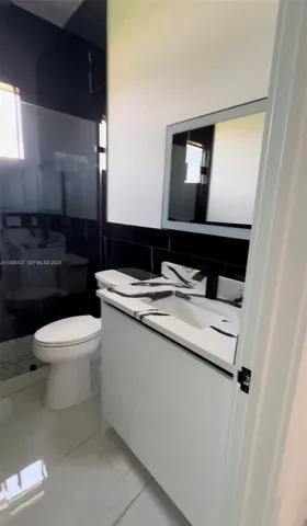 a bathroom with a toilet a sink and mirror